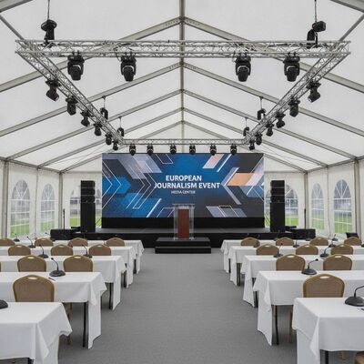 Pressekonferenz, Medienzentrum, Festzelt, professionelle AV-Integration, Bühne, Podium, europäisches Journalismus-Event, Überdachung